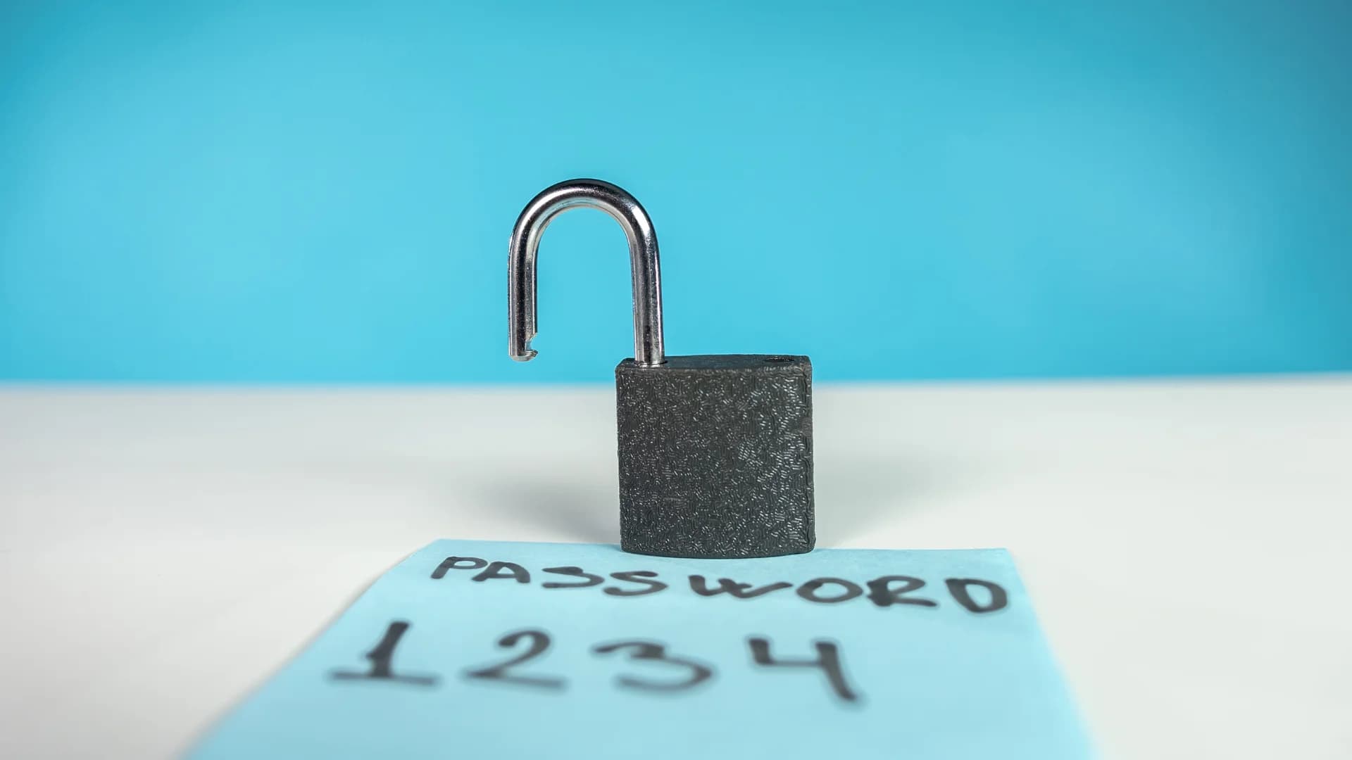 An open padlock resting on a sticky note reading “password 1234”